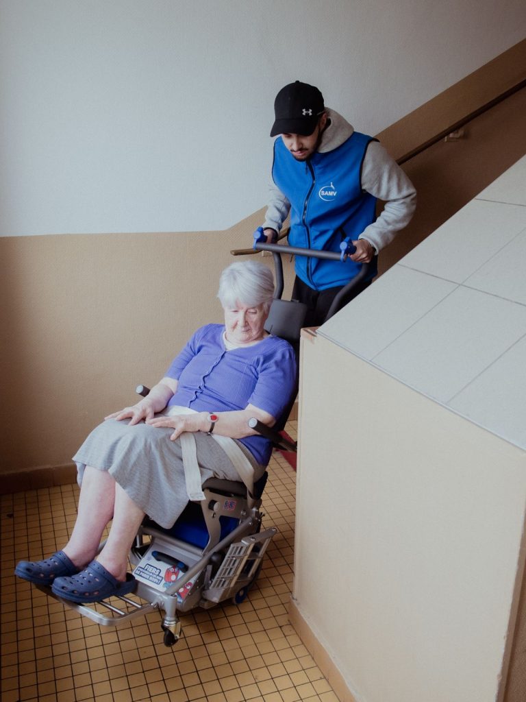 Assistant à Mobilité Verticale SAMV accompagne une locataire en fauteuil roulant